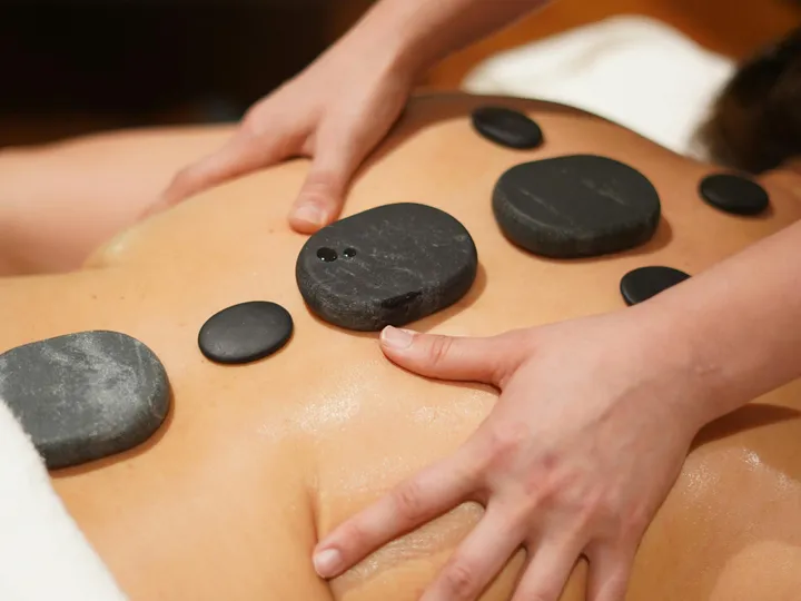 Erhitzte Basaltsteine auf dem Rücken — Hot-Stone-Massage