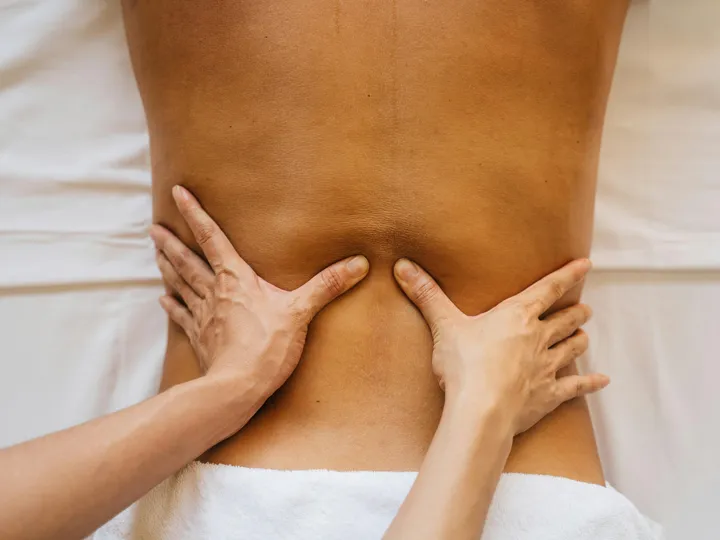 Hände massieren sanft den Rücken — Klassische Massage